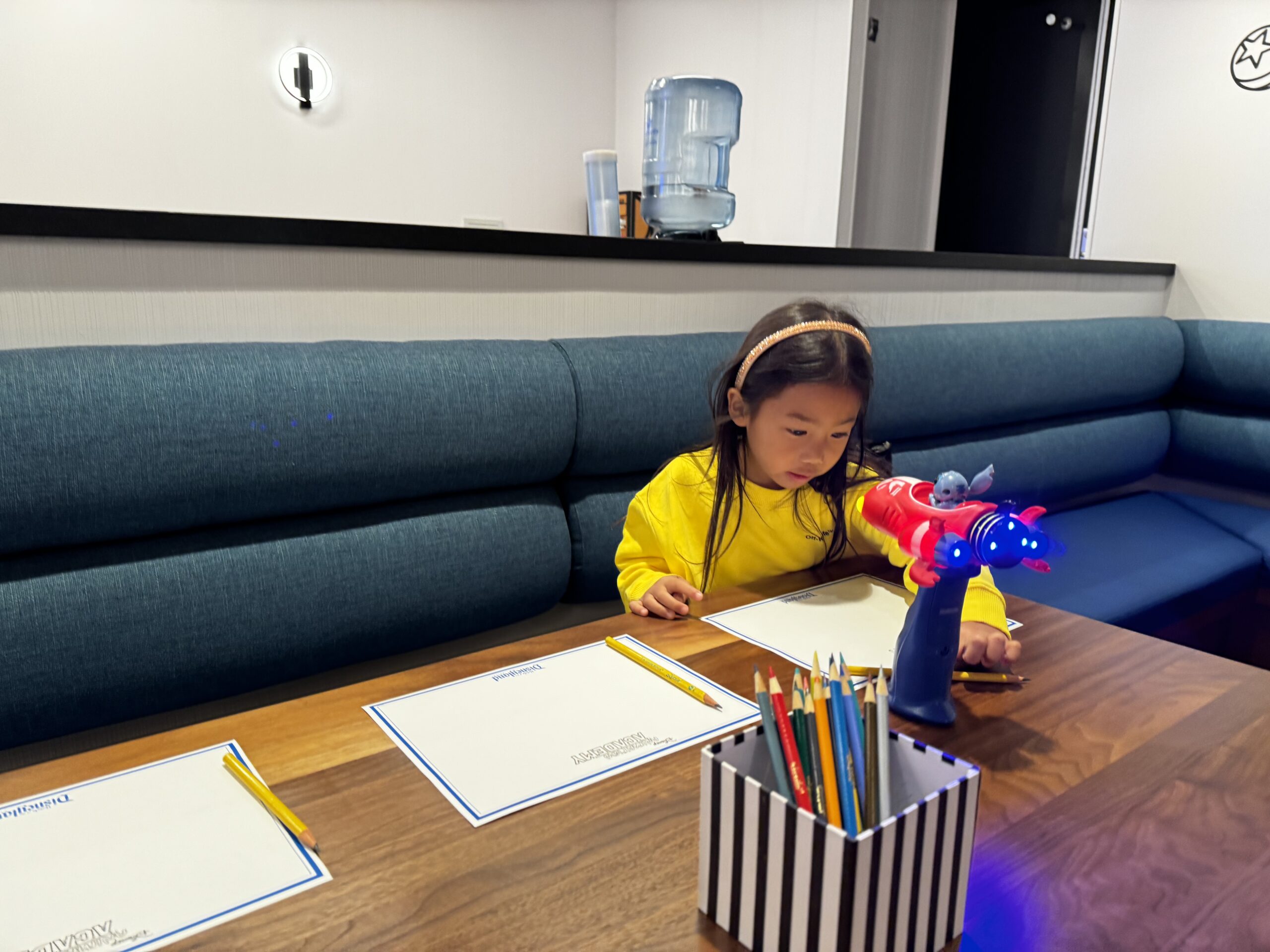 Person sketching at a desk surrounded by art supplies.